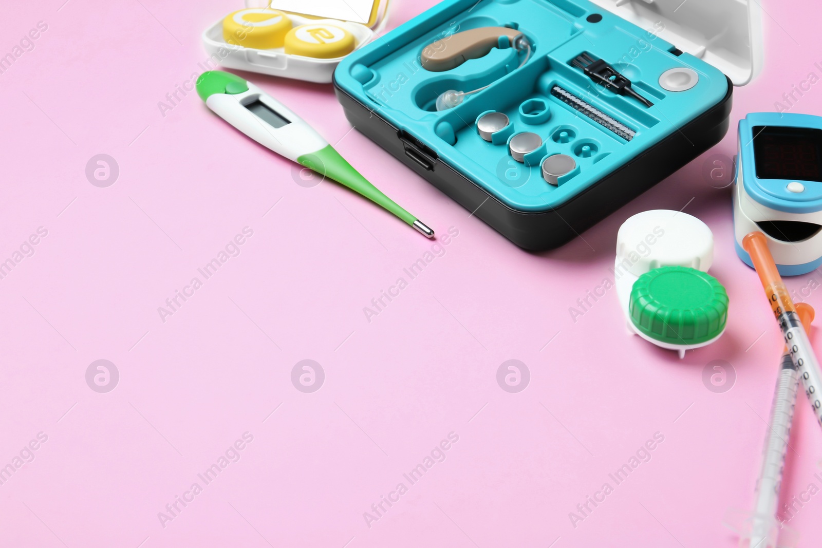 Photo of Hearing aid and medical objects on color background. Space for text