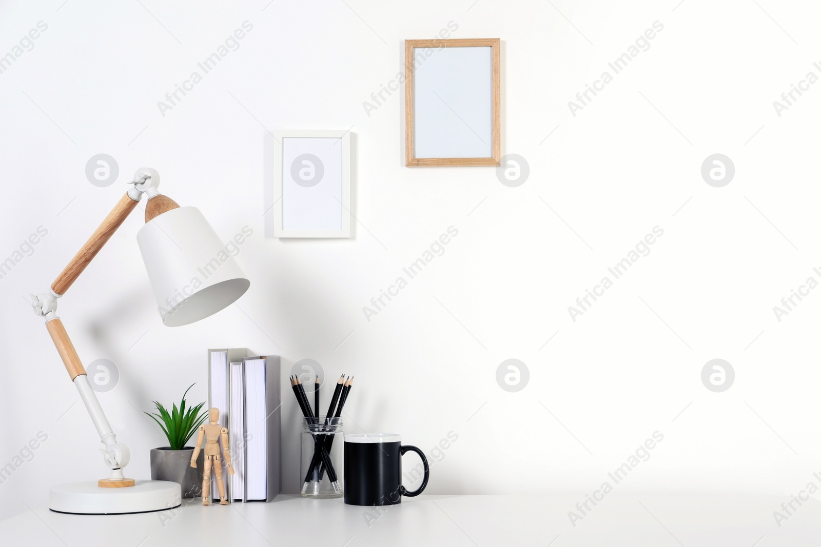 Photo of Comfortable workplace with white desk near wall at home