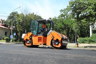 Photo of Roller working on city street. Road repairing