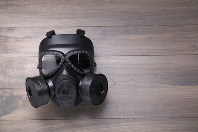 One gas mask on wooden background, top view. Space for text