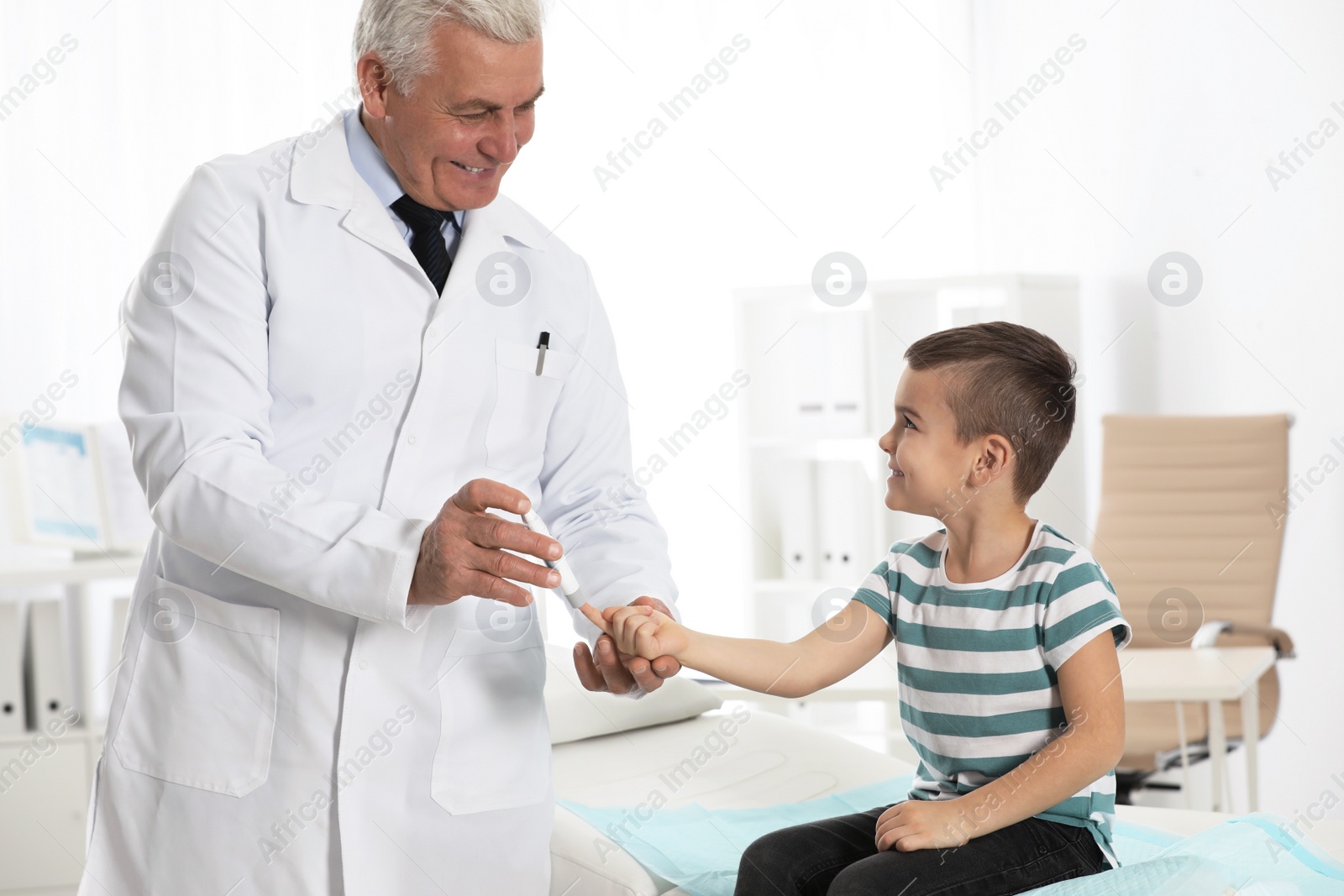 Photo of Little patient and doctor with lancet pen in hospital. Diabetes control