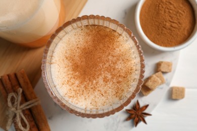 Photo of Delicious eggnog with anise on white table, flat lay