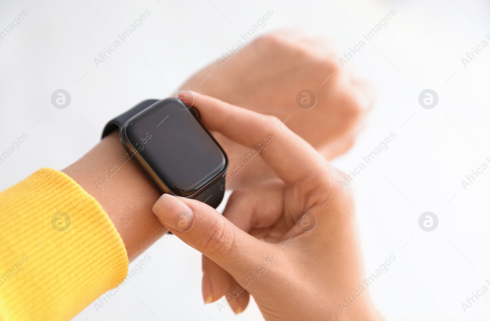 Image of Woman checking stylish smart watch on light background, closeup