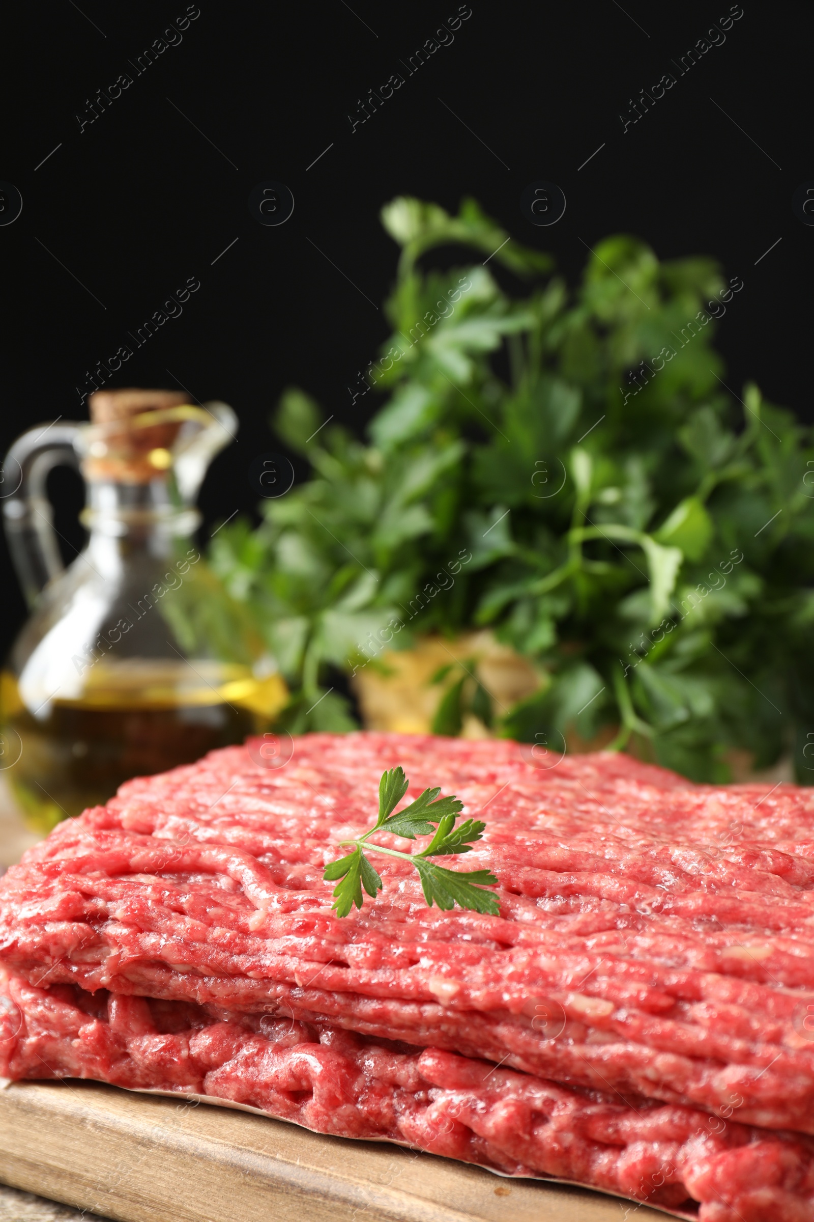 Photo of Raw ground meat and parsley on table