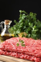 Photo of Raw ground meat and parsley on table