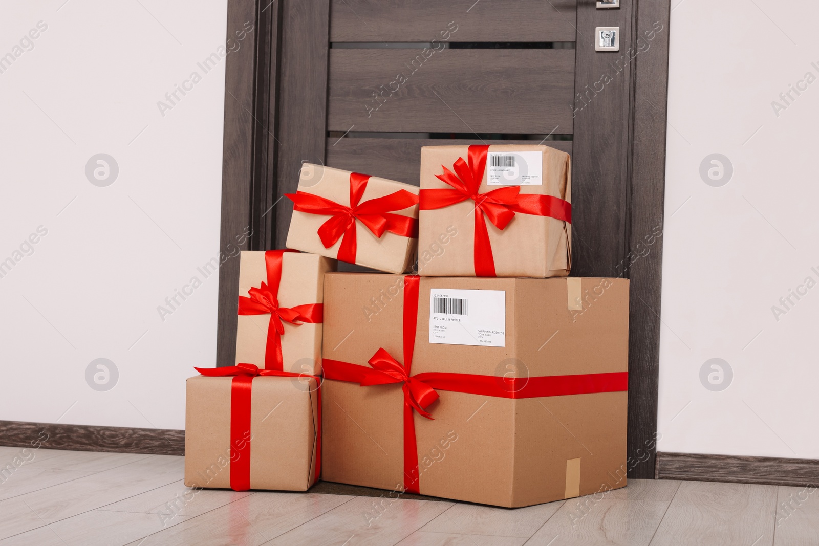 Photo of Christmas gift boxes on floor near door. Sending present by mail