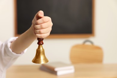 Photo of Boy ringing school bell in classroom, closeup. Space for text