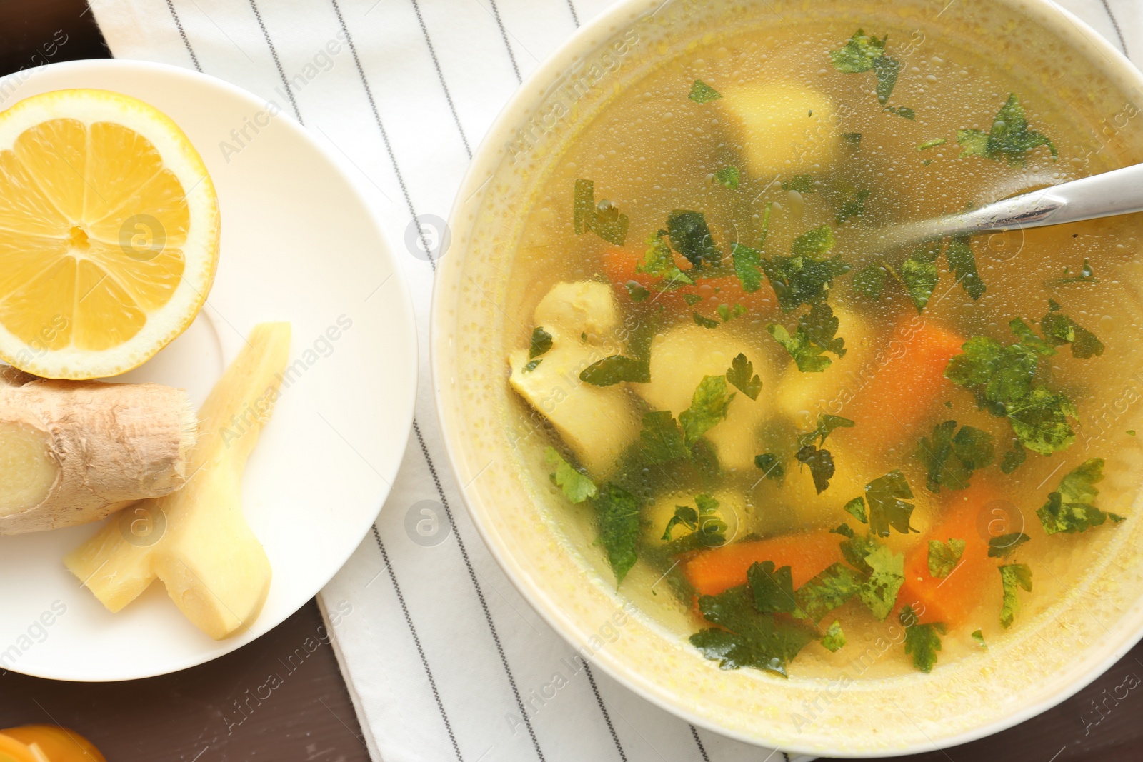 Photo of Bowl with delicious hot broth on table, top view. Cold treatment