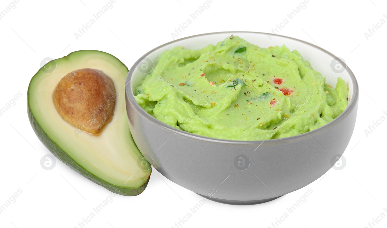 Photo of Bowl of delicious guacamole and fresh avocado isolated on white