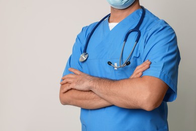 Nurse in medical uniform with stethoscope on white background, closeup. Space for text