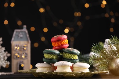 Photo of Beautifully decorated Christmas macarons and fir branches against blurred lights