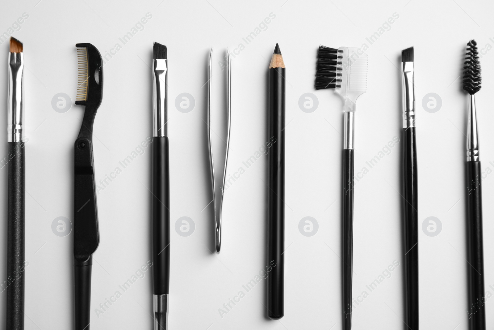 Photo of Set of professional eyebrow tools on white background, flat lay