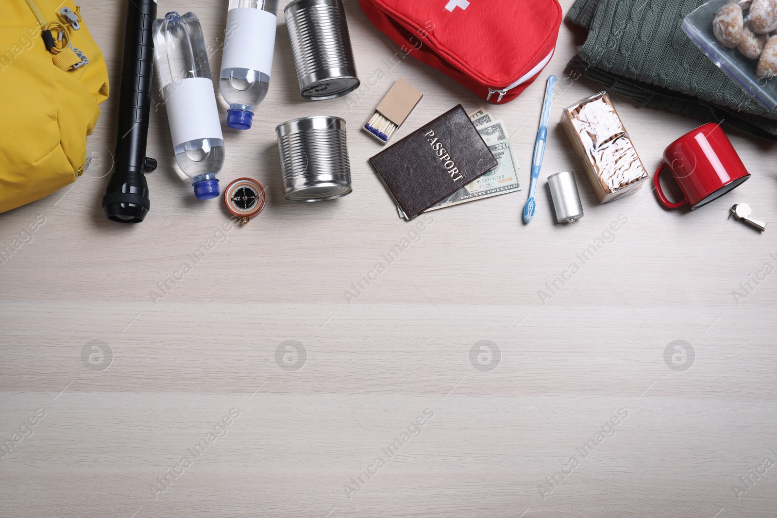 Photo of Earthquake supply kit on wooden table, flat lay. Space for text