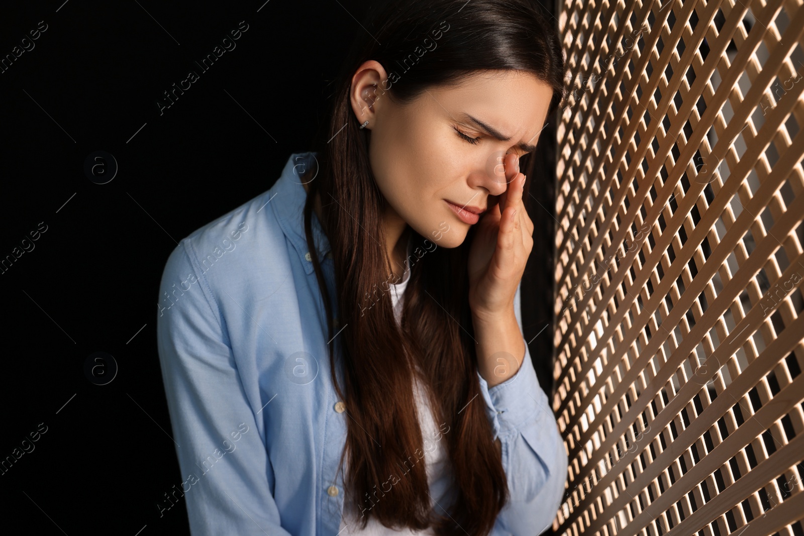 Photo of Upset woman listening to priest during confession in booth