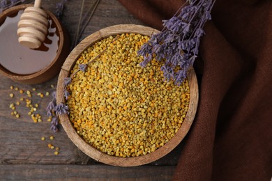 Photo of Fresh bee pollen granules, lavender, honey and dipper on wooden table, flat lay