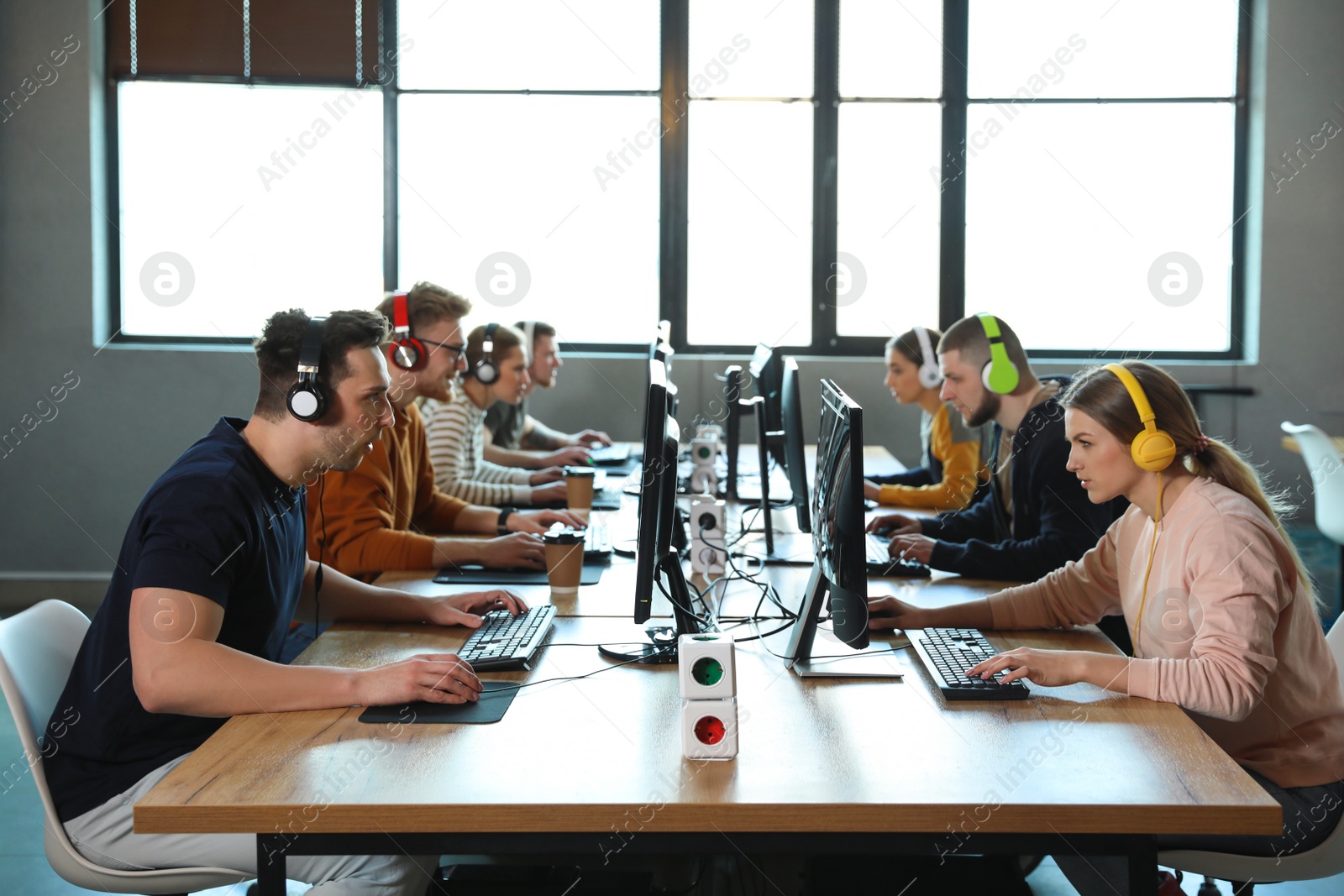 Photo of Group of people playing video games in internet cafe