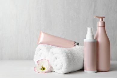 Photo of Different hair products, towel and comb on white wooden table