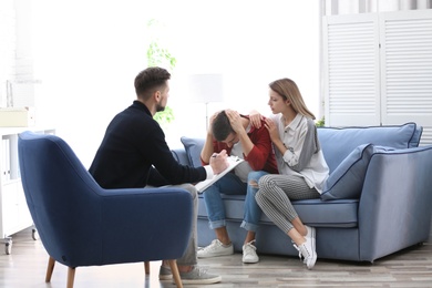 Photo of Young couple with problem at family psychologist office