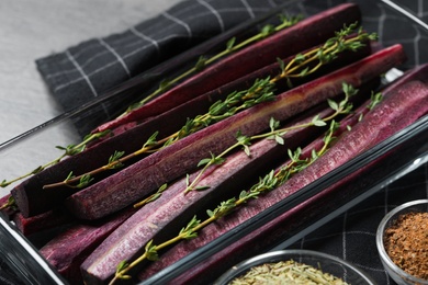 Photo of Raw cut black carrot in baking dish on table, closeup