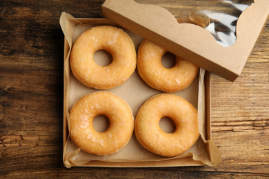 Delicious donuts on wooden table, top view