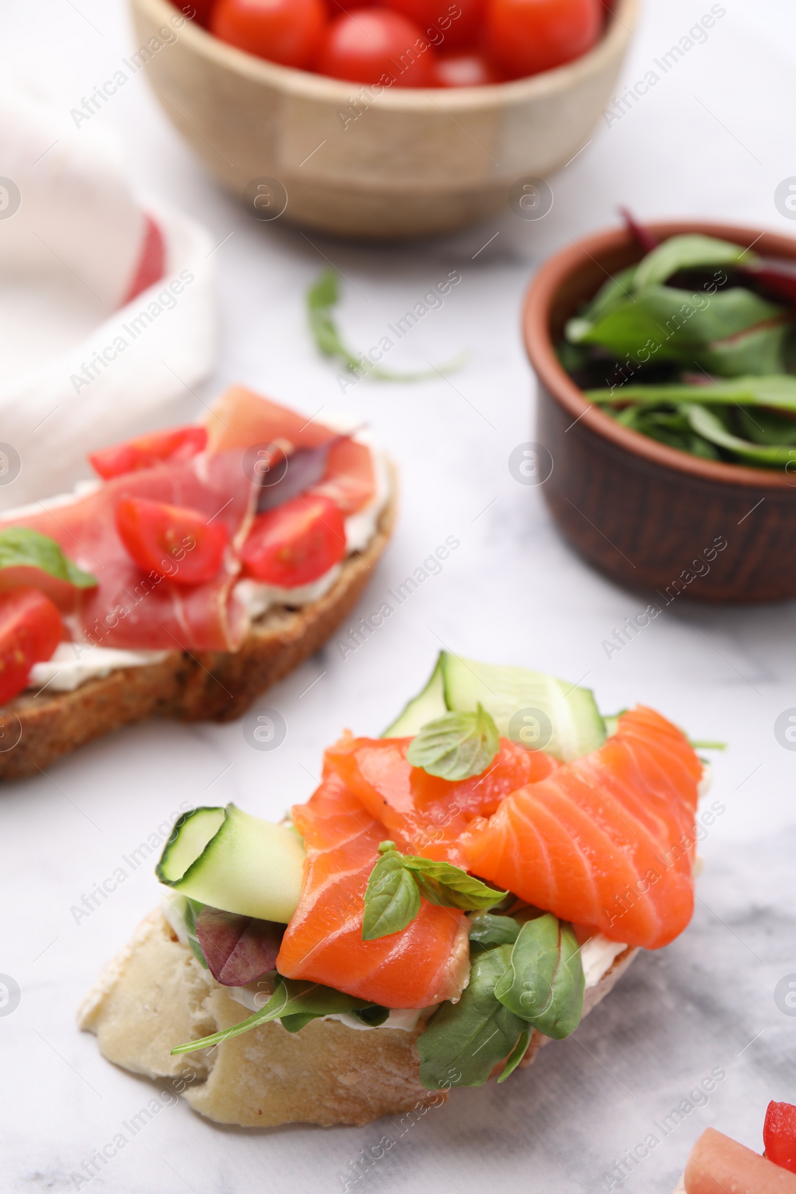 Photo of Different tasty bruschettas on white marble table