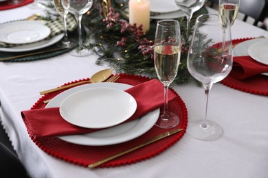 Photo of Christmas table setting with festive decor and dishware