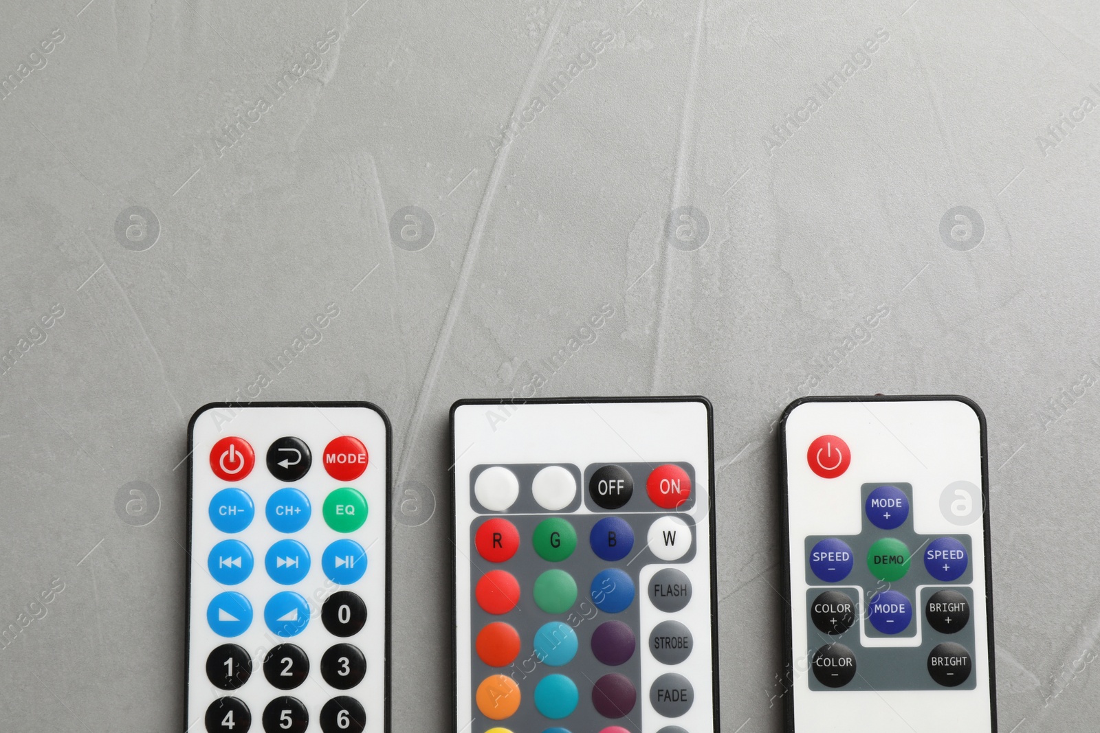 Photo of Remote controls on grey table, flat lay. Space for text