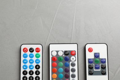 Remote controls on grey table, flat lay. Space for text