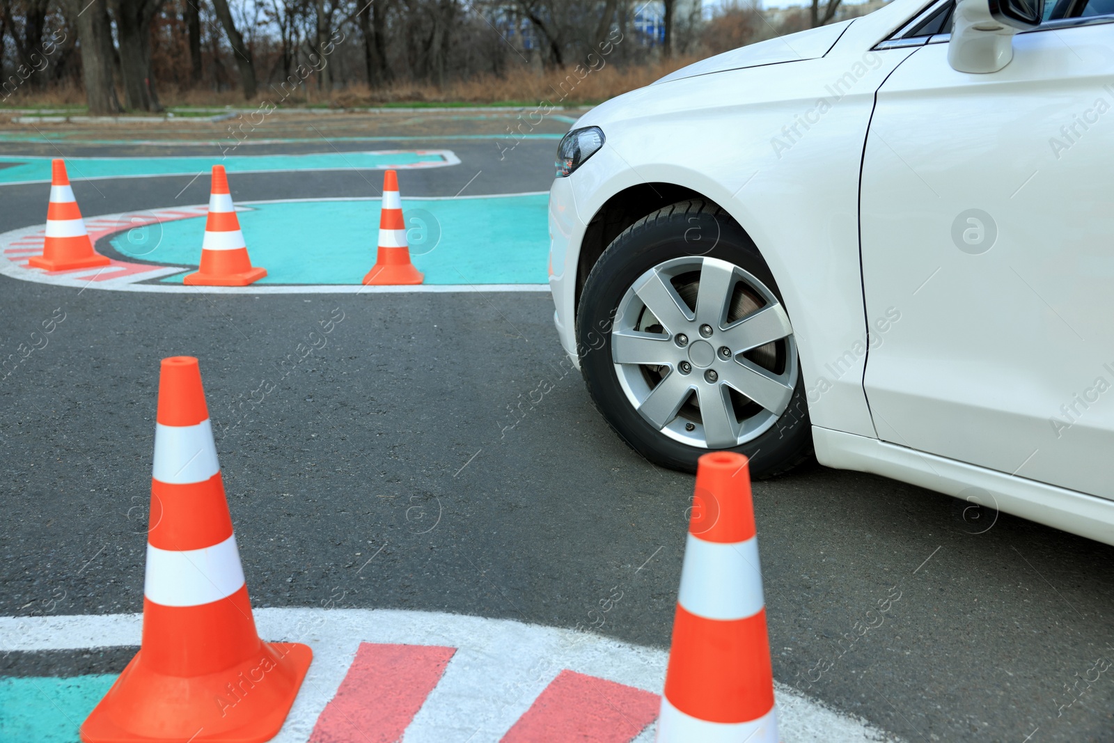 Photo of Modern car on test track with traffic cones, closeup. Driving school