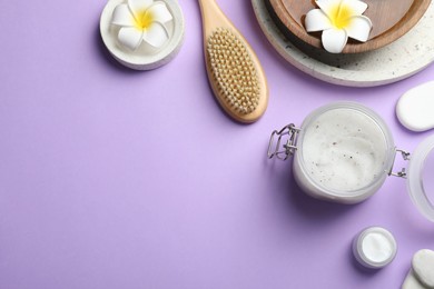 Photo of Flat lay composition with body scrub and plumeria flowers on violet background, space for text