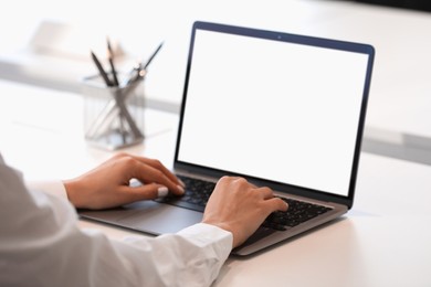 Woman using modern laptop at white desk, closeup