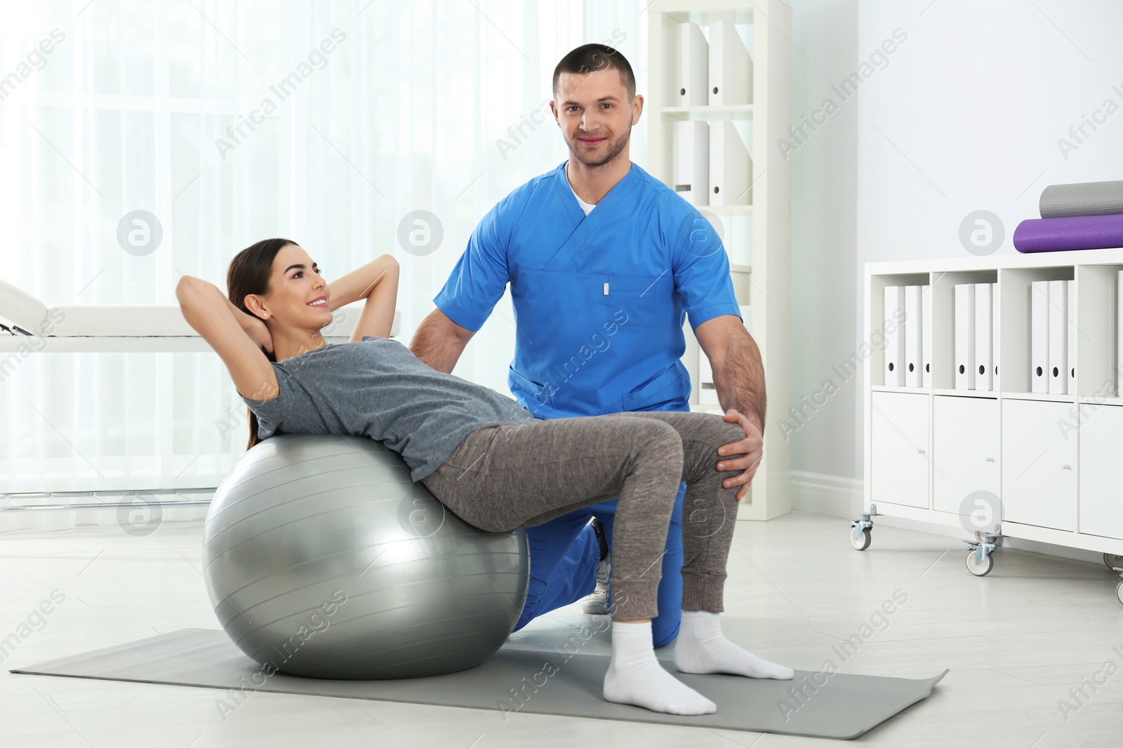 Photo of Doctor working with patient in hospital. Rehabilitation exercises