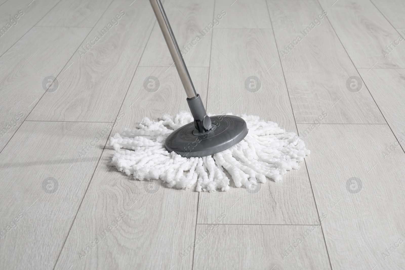 Photo of Cleaning of parquet floor with mop indoors