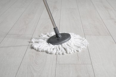 Cleaning of parquet floor with mop indoors