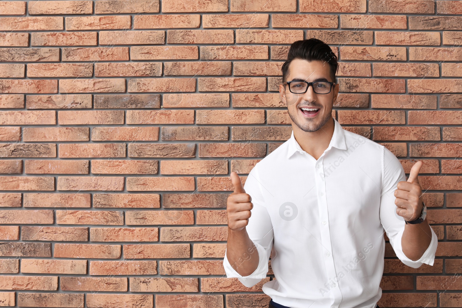 Photo of Portrait of handsome young man and space for text on brick wall background