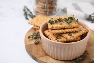 Photo of Cereal crackers with flax, sesame seeds and thyme in bowl on light table, closeup. Space for text
