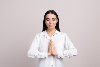 Photo of Young woman meditating on beige background. Stress relief exercise