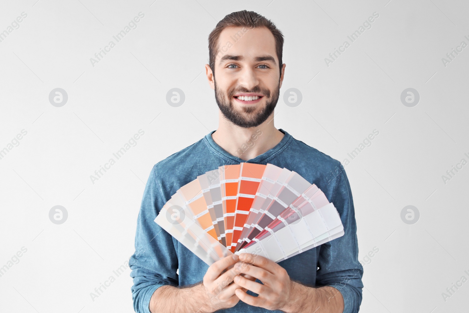 Photo of Young man with color palette on white background