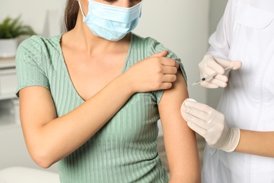 Photo of Doctor giving injection to patient in hospital, closeup. Vaccination day