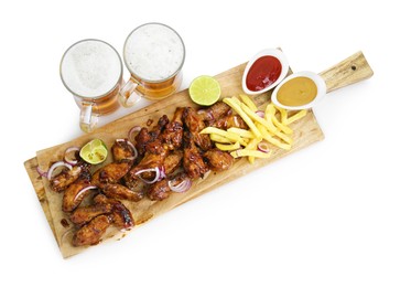 Photo of Wooden board with tasty roasted chicken wings, french fries, mugs of beer and sauces isolated on white, top view