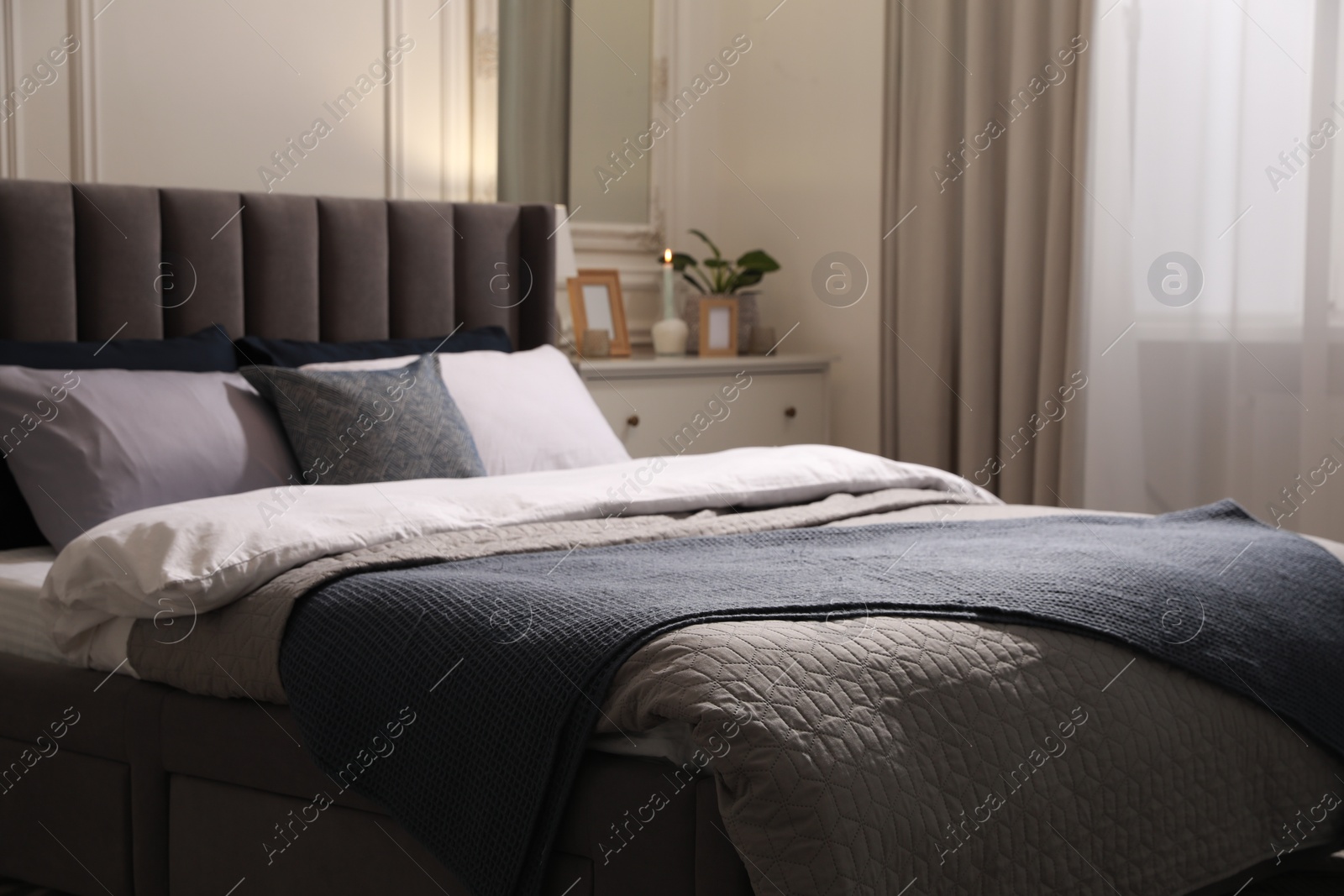 Photo of Comfortable bed with pillows and bedding in stylish room. Interior design