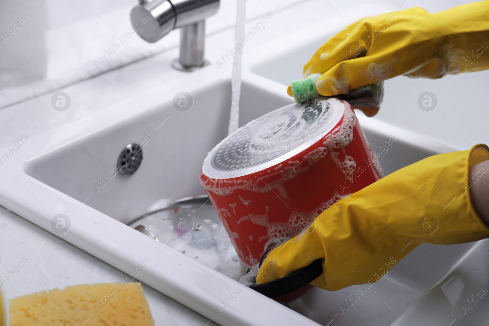 Photo of Woman washing dirty dishes in kitchen sink, closeup