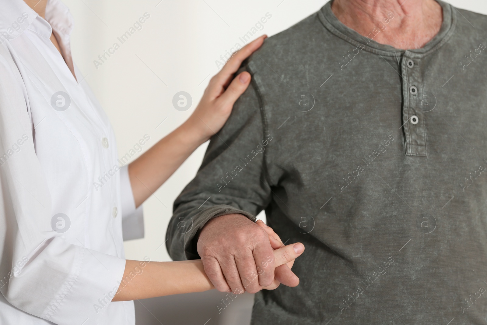 Photo of Elderly man with female caregiver on blurred background, closeup view