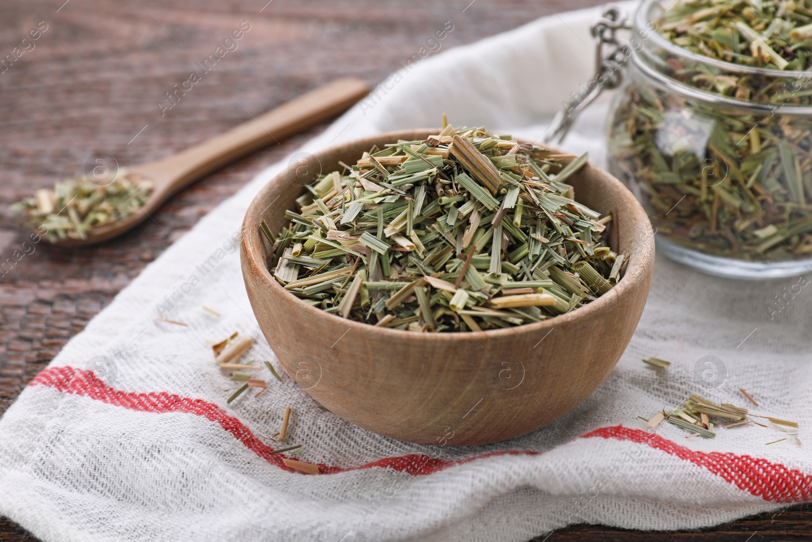 Photo of Bowl with aromatic dried lemongrass on wooden table