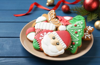 Different tasty Christmas cookies and decor on blue wooden table, closeup. Space for text