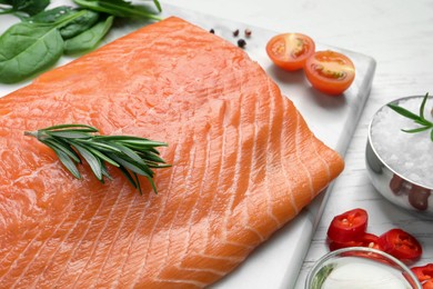 Photo of Fresh raw salmon and ingredients for marinade on white wooden table, closeup