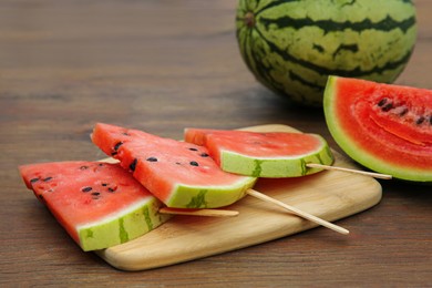 Whole and sliced delicious ripe watermelon on wooden table