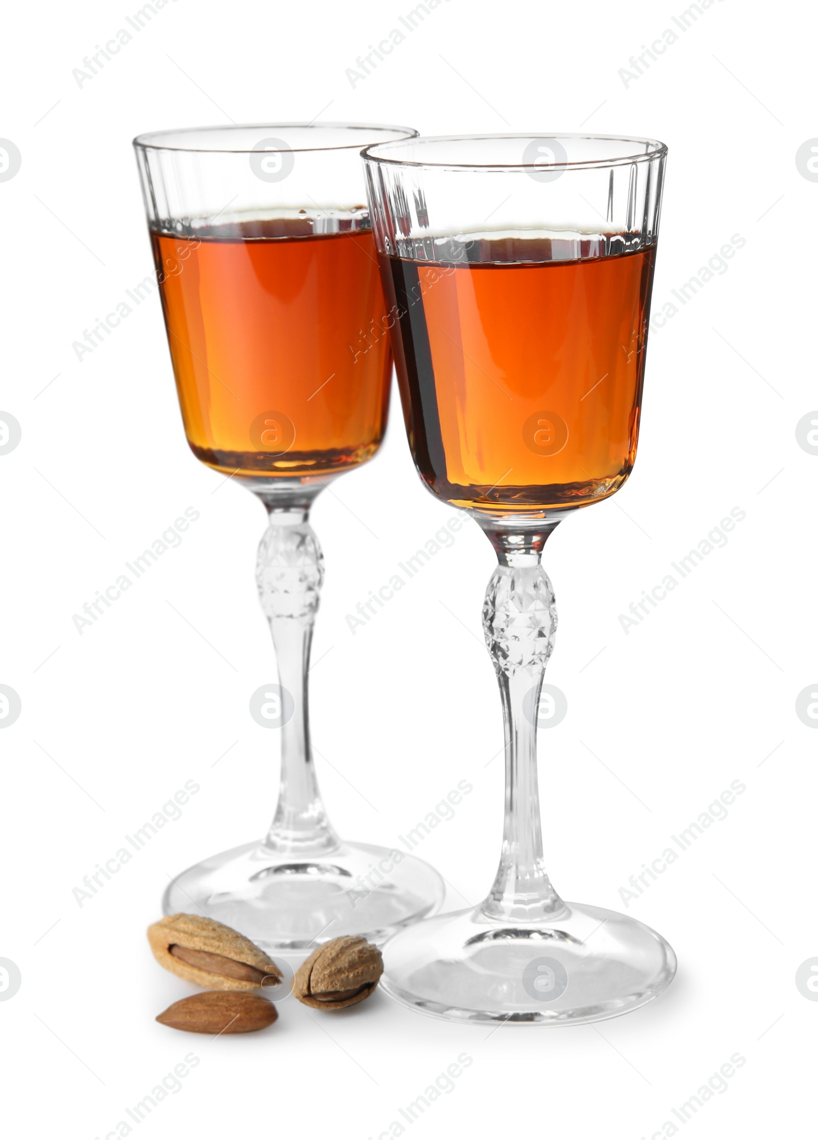 Photo of Liqueur glasses with tasty amaretto and almonds isolated on white