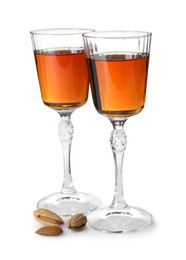 Photo of Liqueur glasses with tasty amaretto and almonds isolated on white