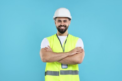 Engineer with hard hat and badge on light blue background